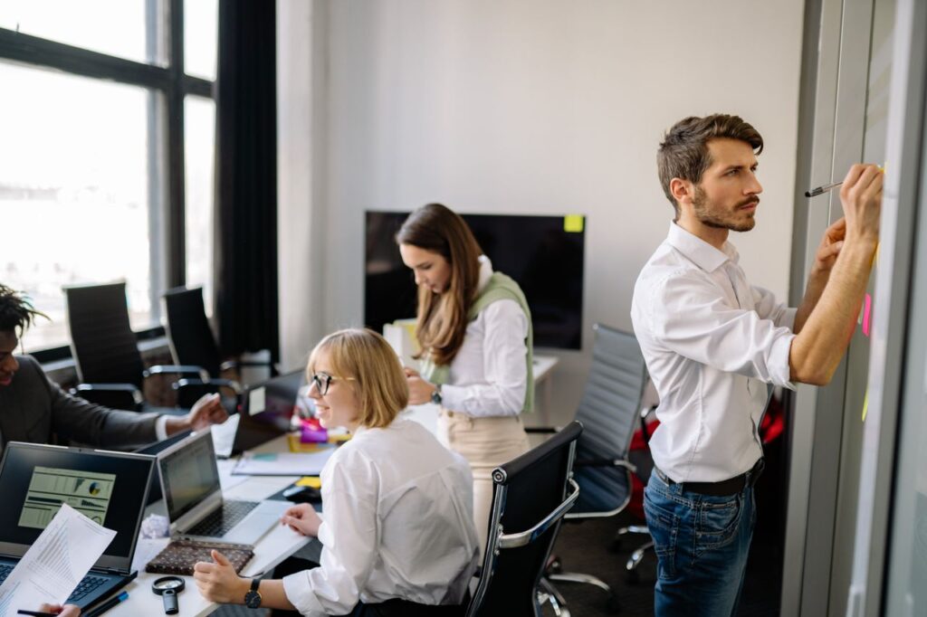 A diverse group of colleagues collaborating in a modern office setting, sharing ideas and planning.
